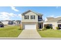 Traditional home exterior boasts a two-car garage, well-kept lawn, and inviting curb appeal on a sunny day at 202 N Light Way, Summerville, SC 29486