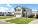 Traditional home exterior showcases a well-kept lawn and two-car garage, perfect for suburban living at 202 N Light Way, Summerville, SC 29486