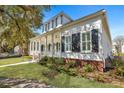 Inviting home with a spacious front porch, black shutters, and beautiful green lawn at 2028 Ironstone Aly, Charleston, SC 29407