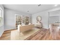 Bright home office featuring hardwood floors, a modern desk, and built-in shelving with decor at 215 W Bradford Pointe Drive Dr, Summerville, SC 29483