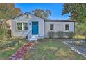 Charming single-story home with white siding, blue door and brick walkway at 2379 Sorentrue Ave, North Charleston, SC 29405