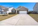 Charming single Gathering home featuring brick accents, a two-car garage, and a well-manicured lawn at 316 Knawl Road, Moncks Corner, SC 29461