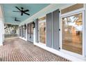 Charming porch showcasing detailed brick flooring, stylish light fixtures, and elegant gray shutters and doors at 4070 Egret Perch Ct, Ravenel, SC 29470