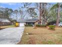 Classic brick home featuring a well-manicured lawn, and a spacious driveway leading to an attached garage at 4604 Garwood Dr, Ladson, SC 29456