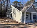 Charming home featuring green siding, a covered porch, and an attached garage, surrounded by a lush landscape at 6201 Drayton St, Ravenel, SC 29470