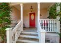 Charming front porch with classic columns, a red front door, and inviting decor at 635 Fair Spring Dr, Charleston, SC 29414