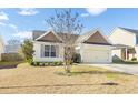 Charming single-story home featuring light yellow siding, a well-maintained lawn, and an attached two-car garage at 7649 Fayetteville Rd, North Charleston, SC 29418