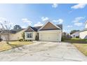 Beautiful one-story home showcasing a well-kept lawn, a two-car garage, and an inviting facade under a clear sky at 7649 Fayetteville Rd, North Charleston, SC 29418