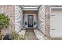 Inviting front entrance with decorated door, lush landscaping, and adjacent garage entry at 7720 Kinston St, North Charleston, SC 29418