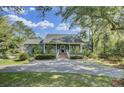Charming home with large front porch, brick stairs and lush landscaping at 8704 Middleton Point Ln, Edisto Island, SC 29438