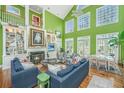 Bright living room featuring high ceilings, a fireplace, and an open floor plan leading to the dining area and natural light at 944 Hammocks Way, Edisto Island, SC 29438