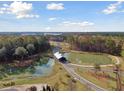 Scenic aerial view of the community, showcasing the covered bridge, pond, walking trails, and lush greenery at 1014 Tulip Shell St, Summerville, SC 29485