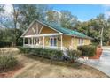 Cozy home featuring a bright exterior, lush landscaping, and a charming porch with decorative details at 104 Gervais St, Walterboro, SC 29488