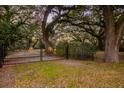 Gated entrance framed by mature trees, enhancing privacy and adding natural beauty to the property at 104 Gervais St, Walterboro, SC 29488