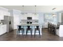 Modern kitchen featuring white cabinets, stainless steel appliances, and a granite countertop island with bar stools at 118 Royal Cainhoy Way, Huger, SC 29450