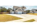 View of the home featuring a spacious driveway, a 2 car garage, and a well manicured lawn at 126 Lakelyn Rd, Moncks Corner, SC 29461