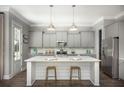 Modern kitchen boasts a large island, stainless steel appliances, gray cabinets, and stylish pendant lighting at 138 Maritime Way, Summerville, SC 29485