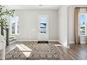 Sunlit foyer featuring a patterned rug, stairway, and light-filled windows that creates a bright and open entrance at 1437 Clay Field Trl, Summerville, SC 29485
