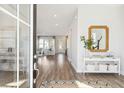 Elegant foyer with wood flooring, complemented by a decorative mirror, console table, and a view of living spaces at 1437 Clay Field Trl, Summerville, SC 29485