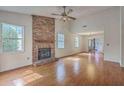 Bright living room features a brick fireplace, hardwood floors, and ample natural light at 158 Commons Way, Goose Creek, SC 29445
