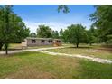 Spacious front yard with mature trees surrounding a cozy, single-story home at 1657 Short Cut Rd, Cross, SC 29436