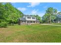 Well-maintained home featuring a large lawn and mature trees for privacy at 203 Horseshoe Rd, Moncks Corner, SC 29461