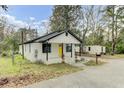 Charming bungalow with a bright yellow front door, black trim and a cozy front porch at 204 Delano St, Saint George, SC 29477