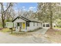 Charming bungalow with a bright yellow front door, detached two car garage and mature landscaping at 204 Delano St, Saint George, SC 29477