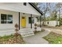 A welcoming porch with a bright yellow front door and well-maintained landscaping at 204 Delano St, Saint George, SC 29477