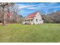 Exterior of home featuring a red metal roof, and a manicured lawn and established trees at 242 Weathers Farm Rd, Bowman, SC 29018