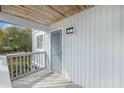 Cozy condo balcony with a tranquil view of lush trees and gray shingle siding at 27 Lagoon Villas, Isle of Palms, SC 29451