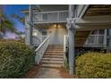 Attractive condo featuring a stairway entrance and well-maintained landscaping at dusk at 27 Lagoon Villas, Isle of Palms, SC 29451