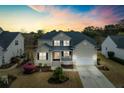 Beautiful home with an attached garage and manicured yard during sunset in a quiet neighborhood at 2788 Carolina Isle Dr, Mount Pleasant, SC 29466