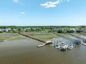 Picturesque aerial view showcasing a pier with boats, surrounding marshlands, and waterfront homes at 2788 Carolina Isle Dr, Mount Pleasant, SC 29466