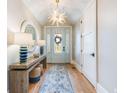 Elegant entryway featuring hardwood floors, a stylish console table, and a beautifully decorated front door that creates a warm welcome at 3204 Waterway Blvd, Isle of Palms, SC 29451