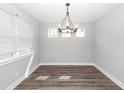 Open dining room with modern chandelier, large windows, and hardwood floors at 413 Renau Blvd, Summerville, SC 29483