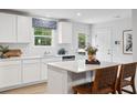 Bright kitchen with white cabinets, island with seating, and stainless steel appliances at 4183 Rising Tide Dr, Summerville, SC 29485