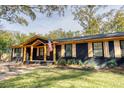 Charming single-story home featuring a dark brick facade, light stained wood accents, and beautifully manicured lawn at 841 Fred St, Charleston, SC 29412