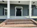 Close-up of a home's front door showing brick steps, white columns, dark siding, and sidelights at 85 Prestwick Pl, Walterboro, SC 29488