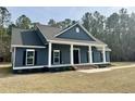 Attractive single-story home featuring dark siding, black shutters, a front porch, and a well-maintained yard at 85 Prestwick Pl, Walterboro, SC 29488