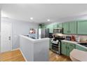 Well-lit kitchen featuring stainless steel appliances, abundant counter space and green cabinets at 8741 Grassy Oak Trl, North Charleston, SC 29420