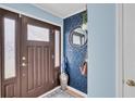 Charming entryway with wood door, blue wallpaper, silver accents and a decorative round mirror at 914 Aleppo Dr, Ladson, SC 29456