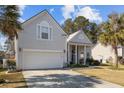 Charming home featuring a two-car garage, manicured lawn, and inviting front porch at 9394 Harroway Rd, Summerville, SC 29485