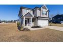 Attractive two-story home with gray siding, a covered entrance, and a well-maintained yard, offering great curb appeal at 112 Edisto Crossing Ct, Ridgeville, SC 29472