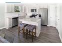 Modern kitchen with granite countertops, stainless steel appliances, an island, and stylish bar stools at 115 Royal Cainhoy Way, Huger, SC 29450