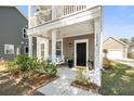 Welcoming front porch features a comfortable swing and manicured landscaping at 1532 Roustabout Way, Charleston, SC 29414