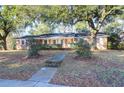Charming brick home featuring a well-manicured lawn and beautiful mature trees at 1595 Dickens St, Charleston, SC 29407