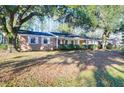 Charming brick home featuring a well-manicured lawn and beautiful mature trees at 1595 Dickens St, Charleston, SC 29407