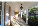 Inviting covered front porch with classic lantern lighting and brick exterior at 1595 Dickens St, Charleston, SC 29407