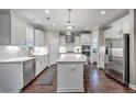 Bright kitchen features white cabinetry, stainless steel appliances, large island, and hardwood floors at 1644 Fishbone Dr, Johns Island, SC 29455